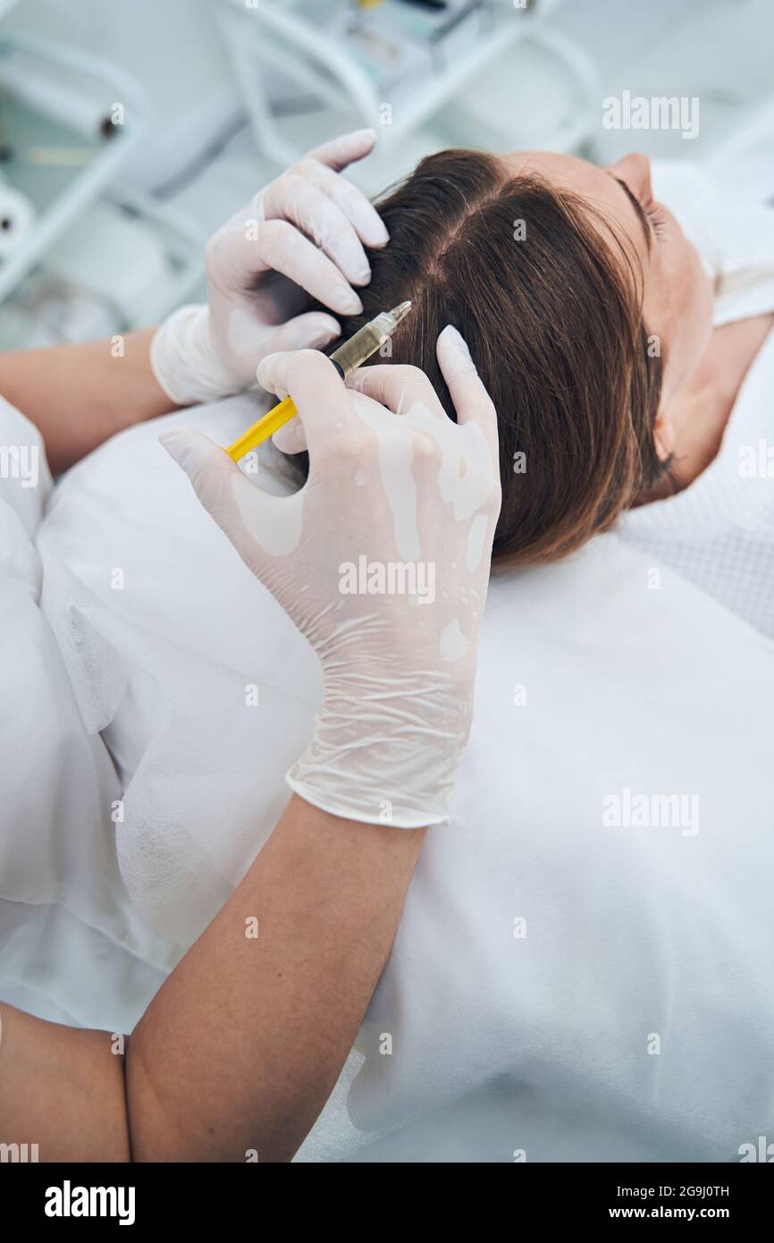 Nahaufnahme von Kosmetologen tun Haar Verfahren Stockfoto