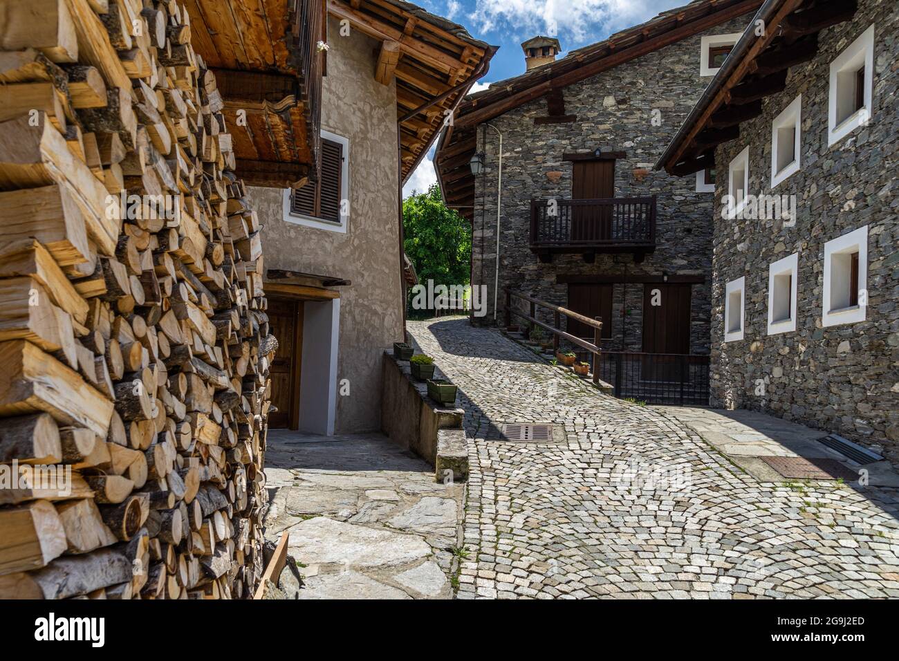 Eine gepflasterte Straße und alpine Häuser in Pontechianle, einem charmanten Dorf im Varaita-Tal, Piemont, Italien Stockfoto