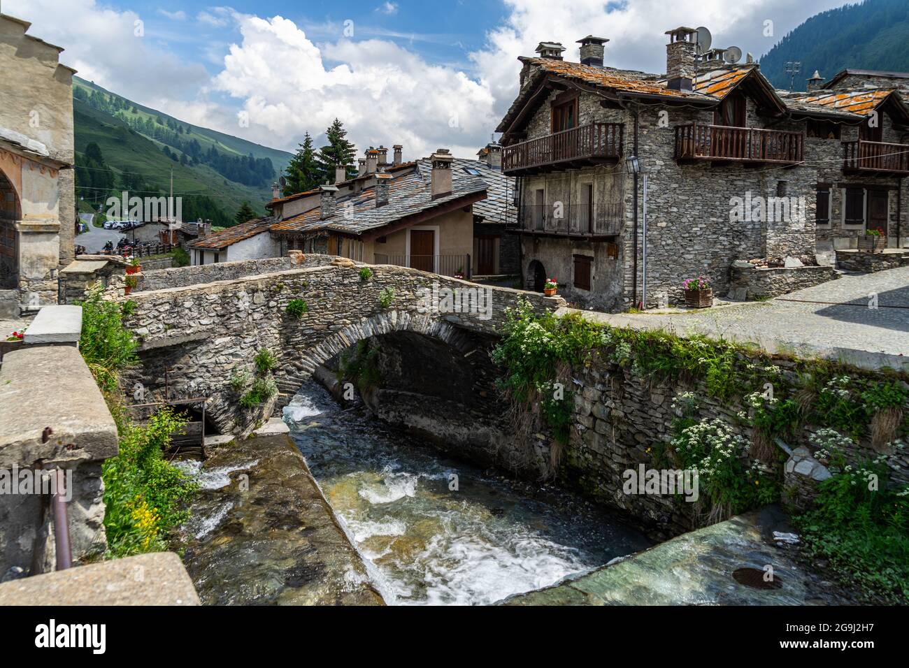 Der Fluss Varaita, der unter einer alten Steinbrücke im Dorf Chianale, Varaita-Tal, Piemont, Italien, fließt Stockfoto