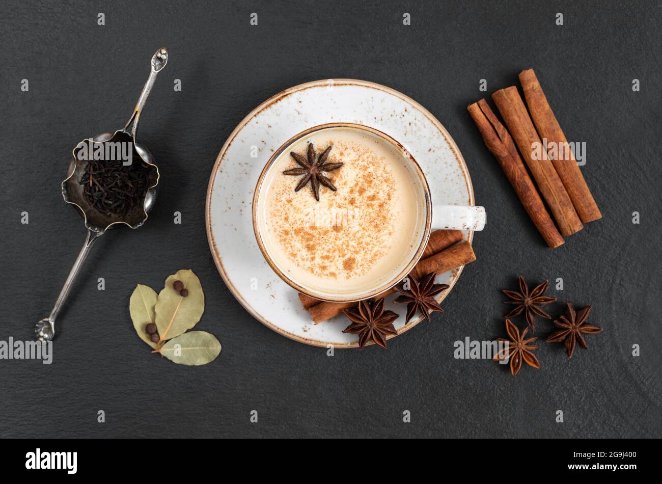 Masala Tee auf einem dunklen Stein Hintergrund. Indisches Heißgetränk mit Milch und Gewürzen. Blick von oben. Stockfoto