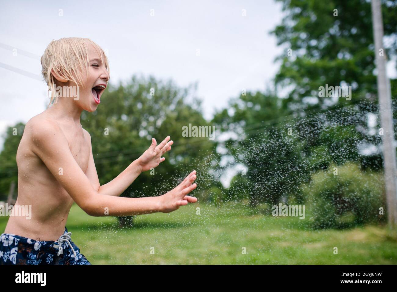 Kanada, Ontario, Kingston, Shirtless boy (8-9) spielt mit Wasser Stockfoto