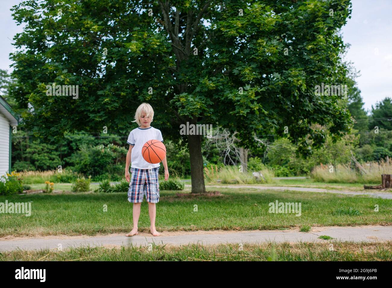 Kanada, Ontario, Kingston, Boy (8-9) spielt Basketball Stockfoto