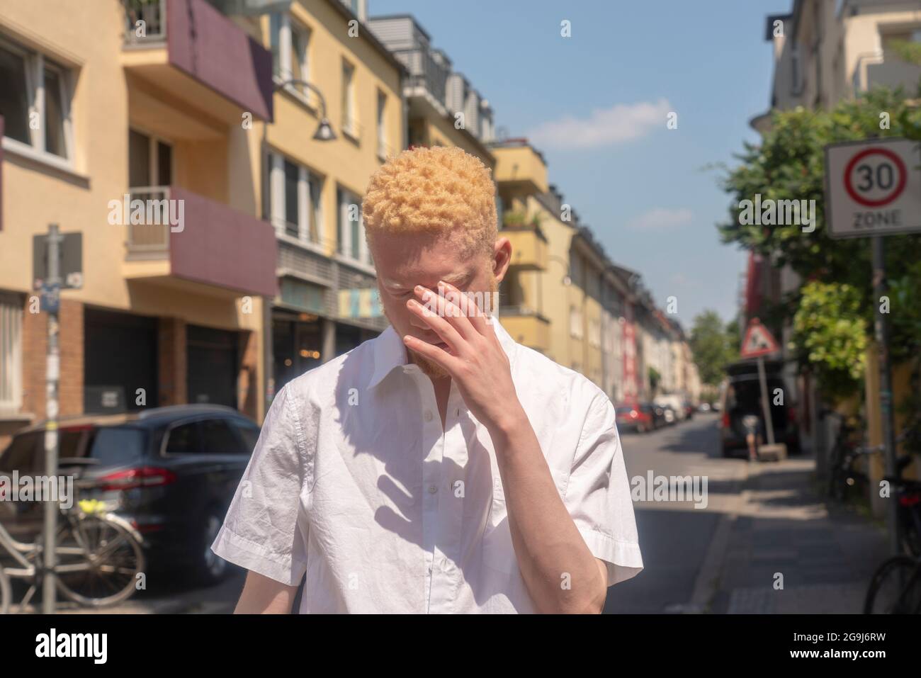 Deutschland, Köln, Albino Mann in weißem Hemd auf der Straße Stockfoto