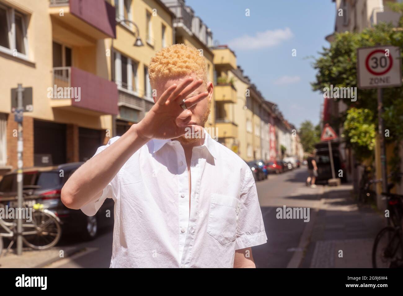 Deutschland, Köln, Albino Mann in weißem Hemd auf der Straße Stockfoto