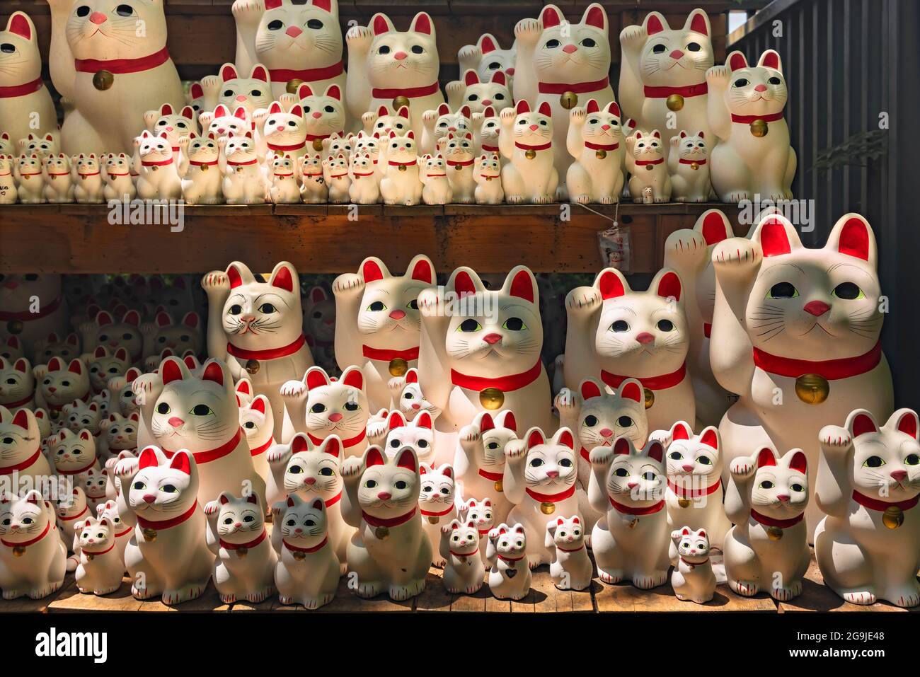 tokio, japan - juli 25 2021: Dutzende von Kawaii japanischen Manekineko Katze Glücksbringer Skulpturen, die die berühmte winkende Katze von Buddhis angeboten darstellen Stockfoto