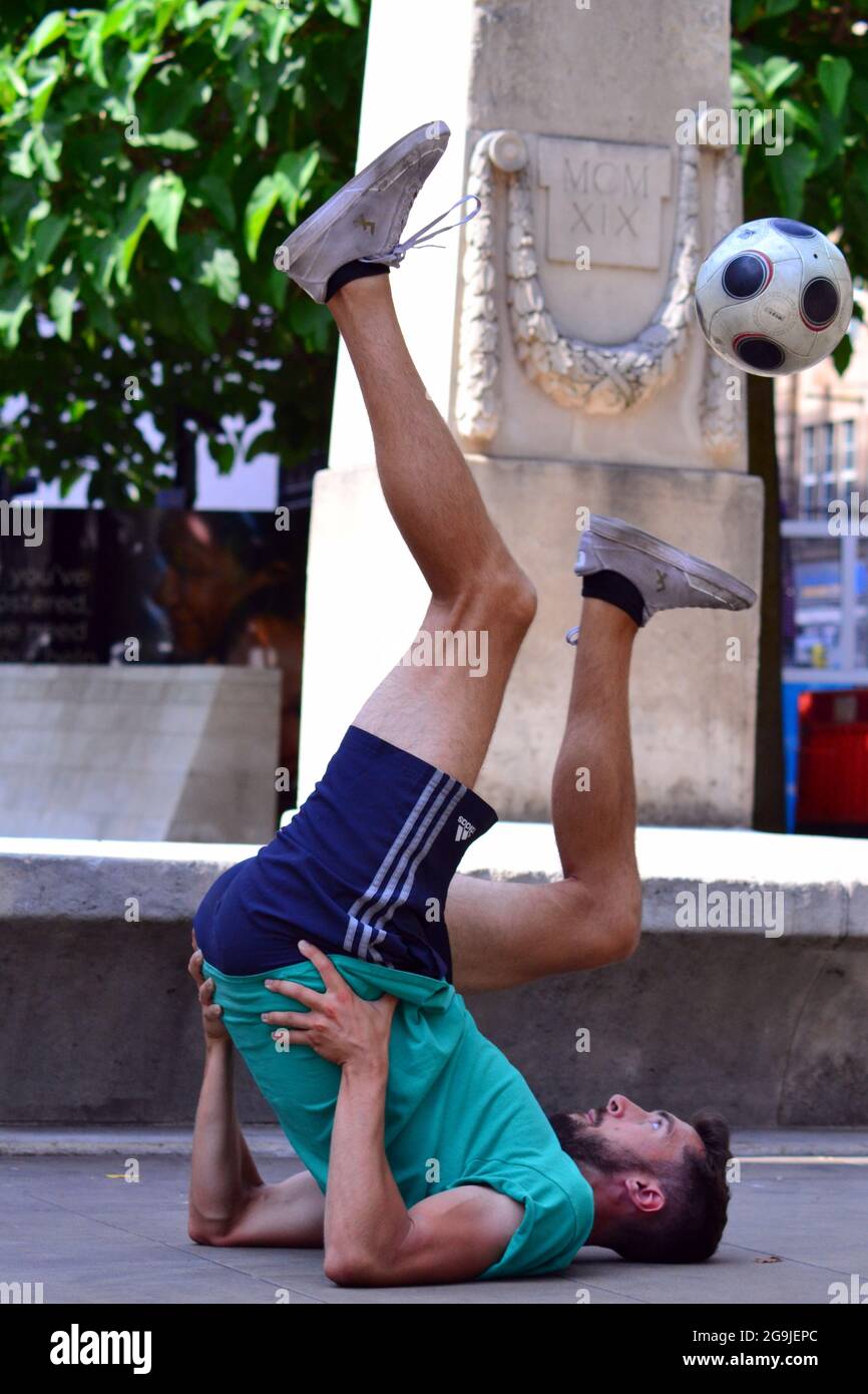 Steve Gray, ein professioneller Fußballexperte und Freestyle-Fußballexperte, demonstriert im Stadtzentrum von Manchester, England, Großbritannien, am 26. Juli 2021, den Ball auf dem Fuß zu jonglieren. Stockfoto