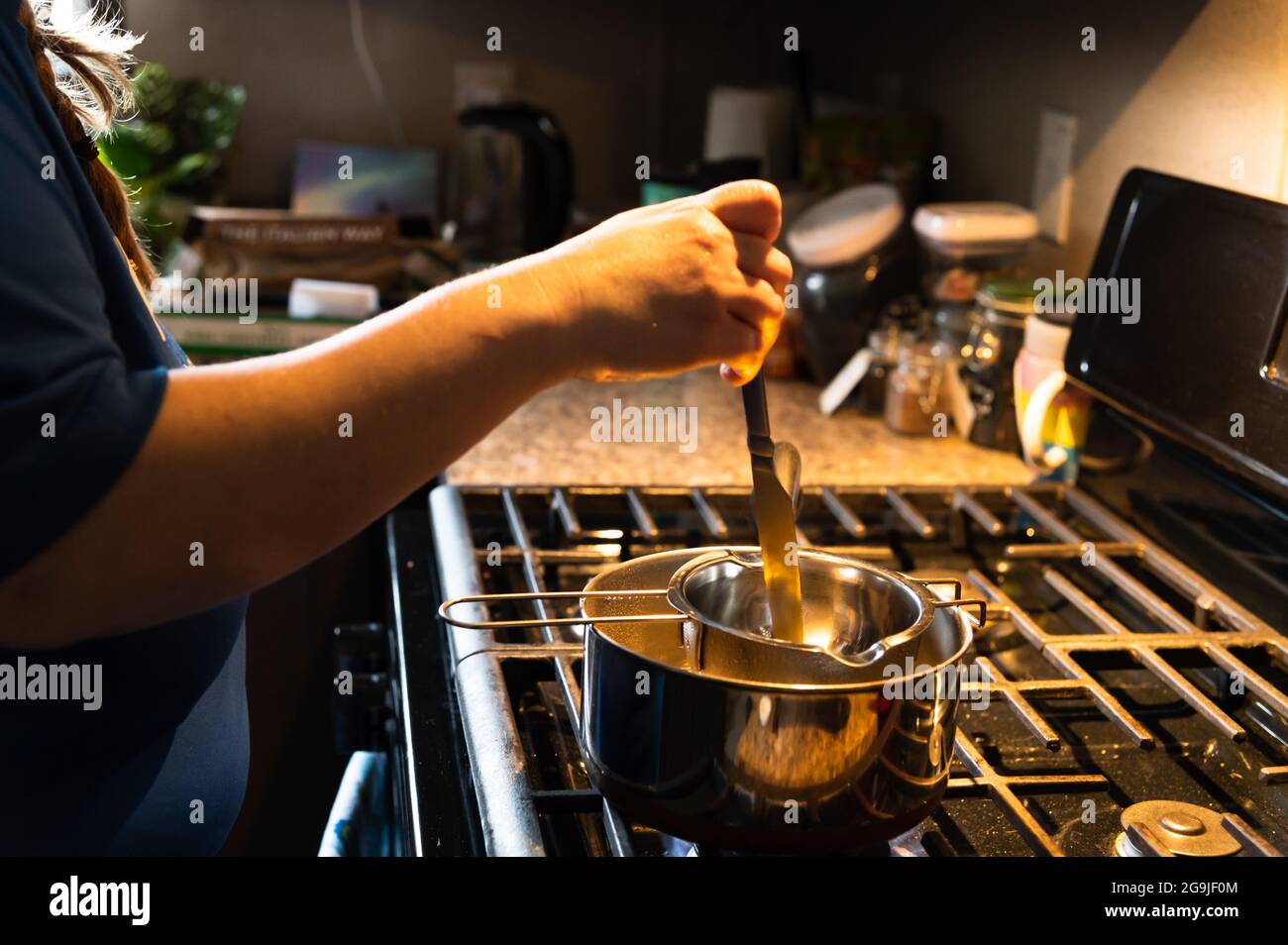 Frau Rühren Doppelkessel Inhalt Stockfoto