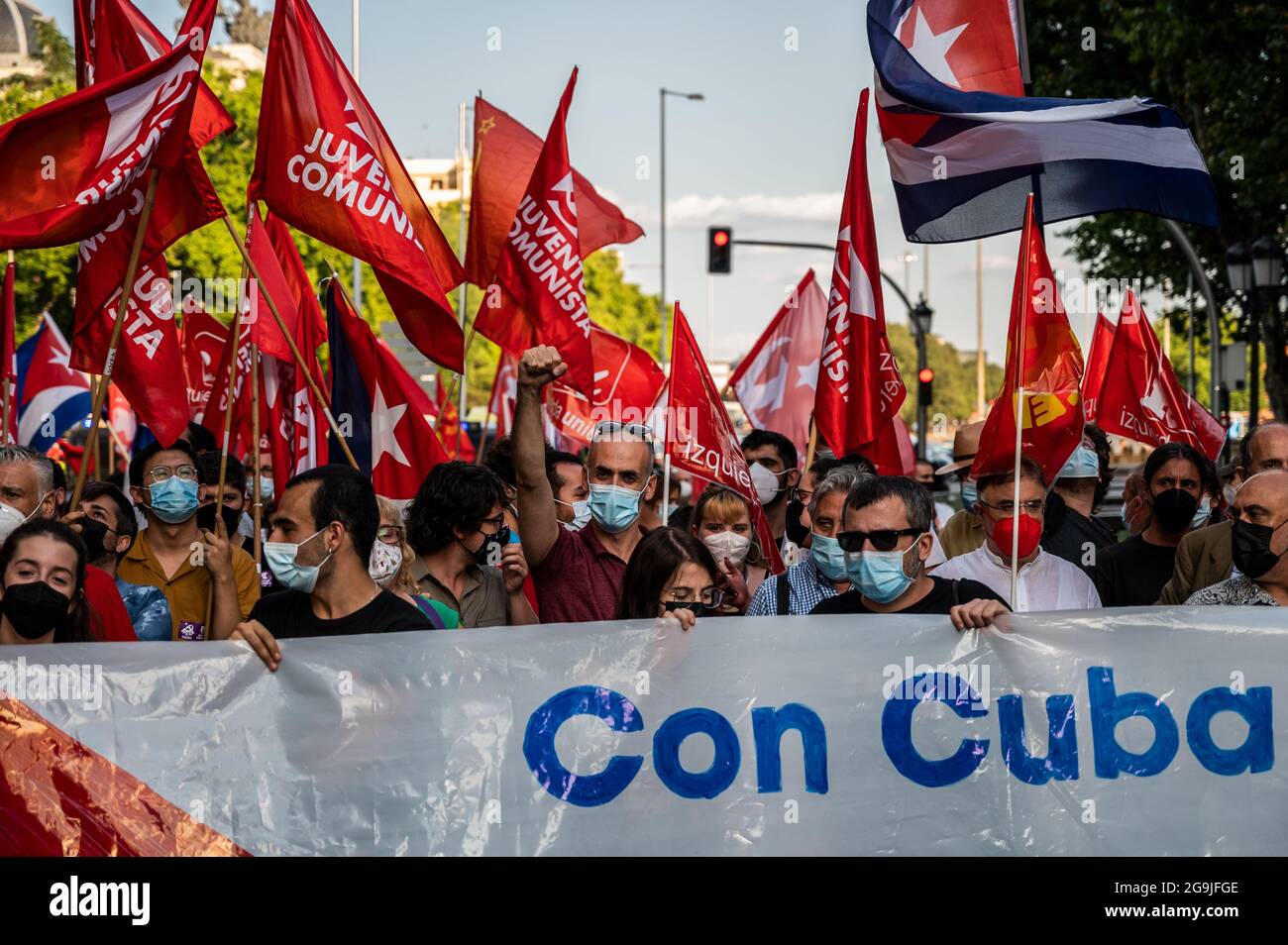 Madrid, Spanien. Juli 2021. Demonstranten mit Fahnen und Plakaten während einer Demonstration gegen das US-Wirtschaftsembargo gegen Kuba, zeitgleich mit dem 26. Juli, dem Tag, an dem die kubanische Revolution 1953, vor 68 Jahren, begann. Quelle: Marcos del Mazo/Alamy Live News Stockfoto