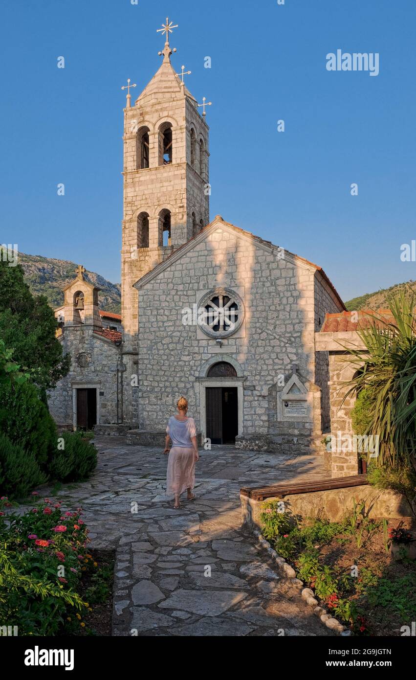 Eine Frau tritt in die Kirche des Klosters Rezevici, Montenegro, ein Stockfoto