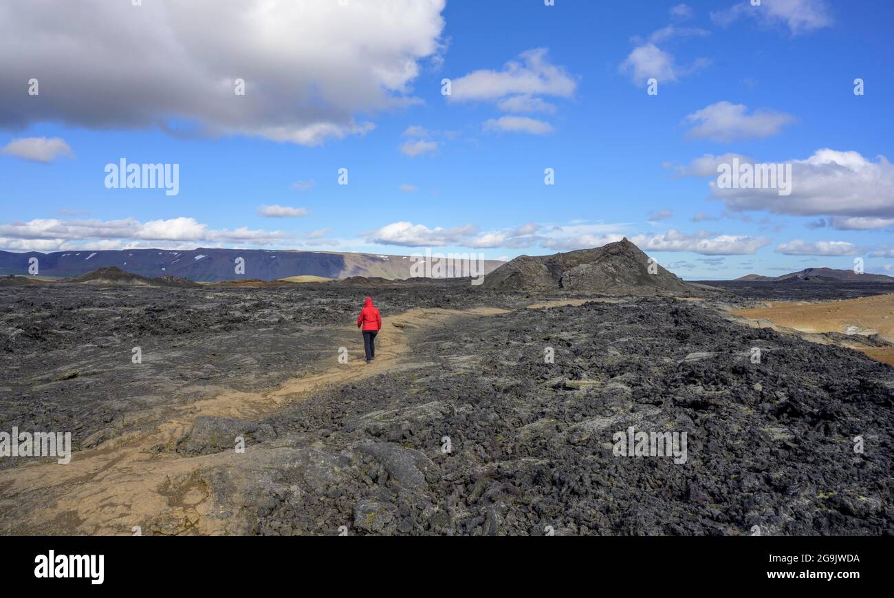 Frau, die über das Lavafeld des Krafla-Vulkansystems zum Krater (letzter Ausbruch 1984), Skutustaoir, Norourland eystra, Island, geht Stockfoto
