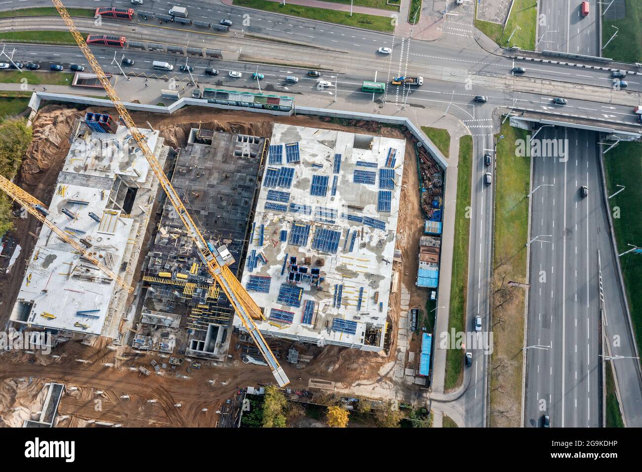 Stadtbaustelle mit funktionierenden Turmdrehkranen. Neue mehrgeschossige Gebäude im Bau. Luftbild. Stockfoto