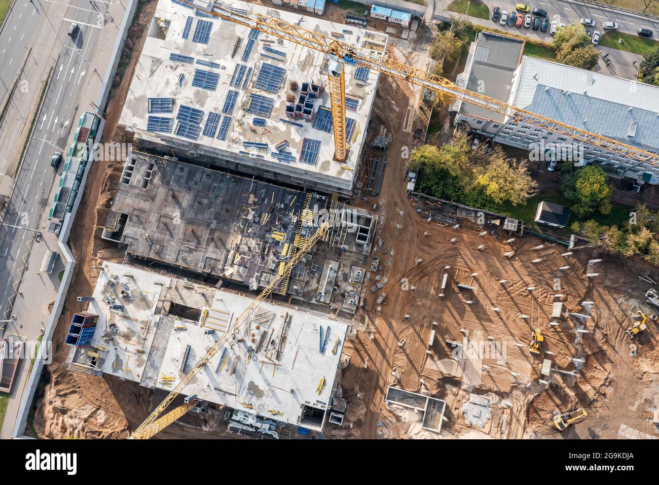 Viel befahrene Baustelle mit Arbeitskränen und Maschinen für Erdarbeiten. Luftaufnahme von fliegender Drohne Stockfoto