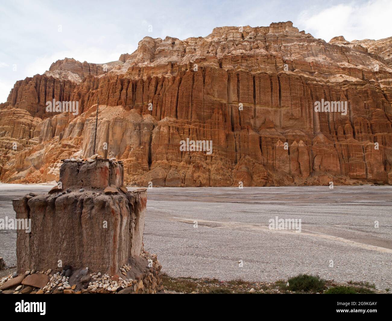 Eingehöhlte orangefarbene Sandsteinfelsen und Chorten über Kali Gandaki in der Nähe von Chhusang, Upper Mustang, Nepal Stockfoto