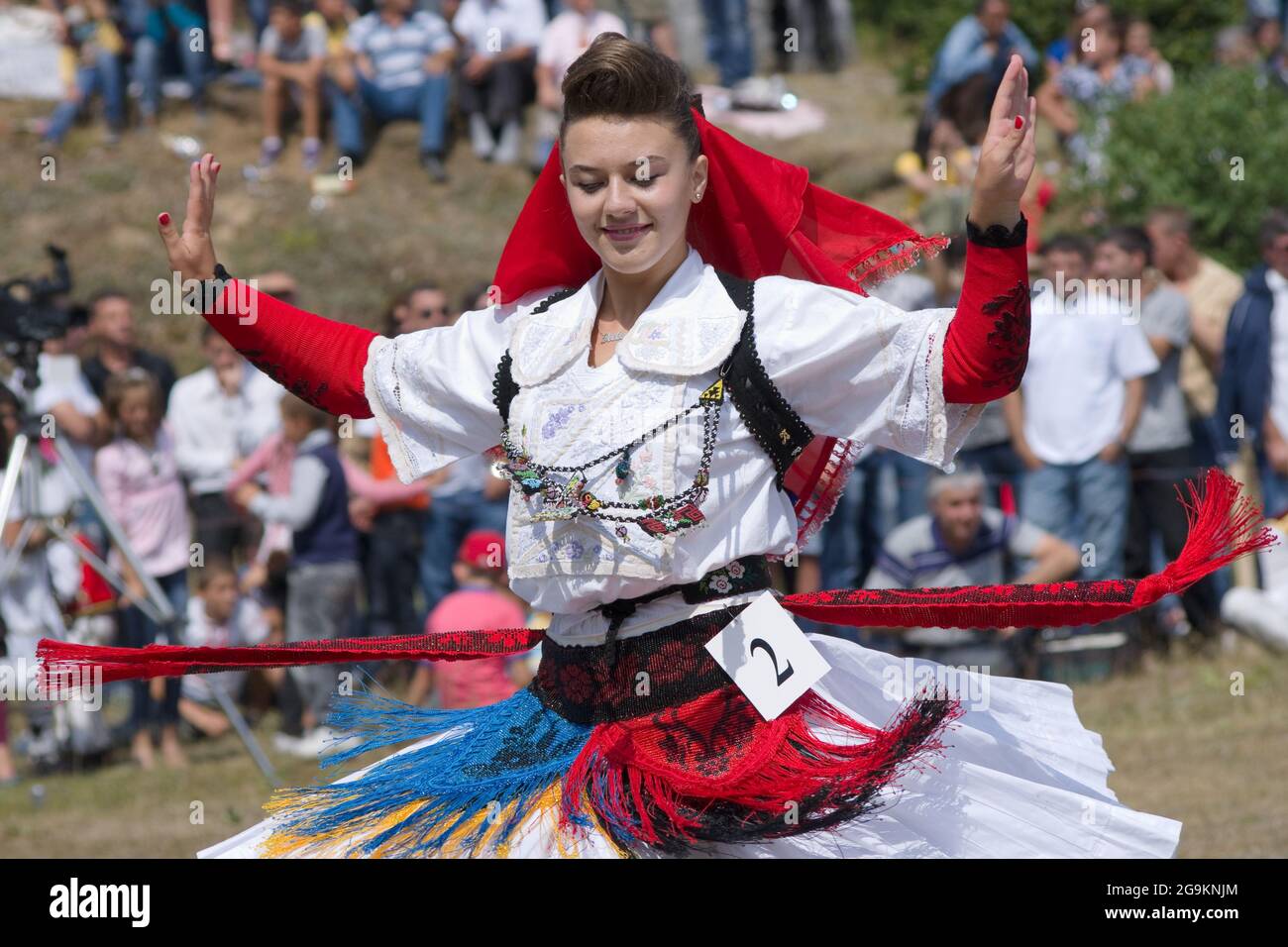 Lepushe, Albanien - 11. August 2012: Hübsches Mädchen tanzt mit den in traditioneller Albaner gekleideten Mädchen beim Klang traditioneller Musik und nimmt daran Teil Stockfoto