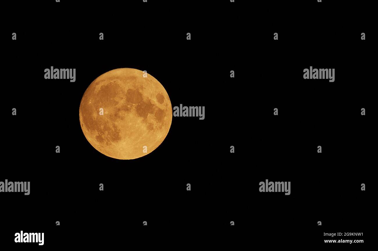 Die Bewegung des orangenen Mondes über den Himmel am 23. Juli 2021. Halloween Mond Konzept. Stockfoto