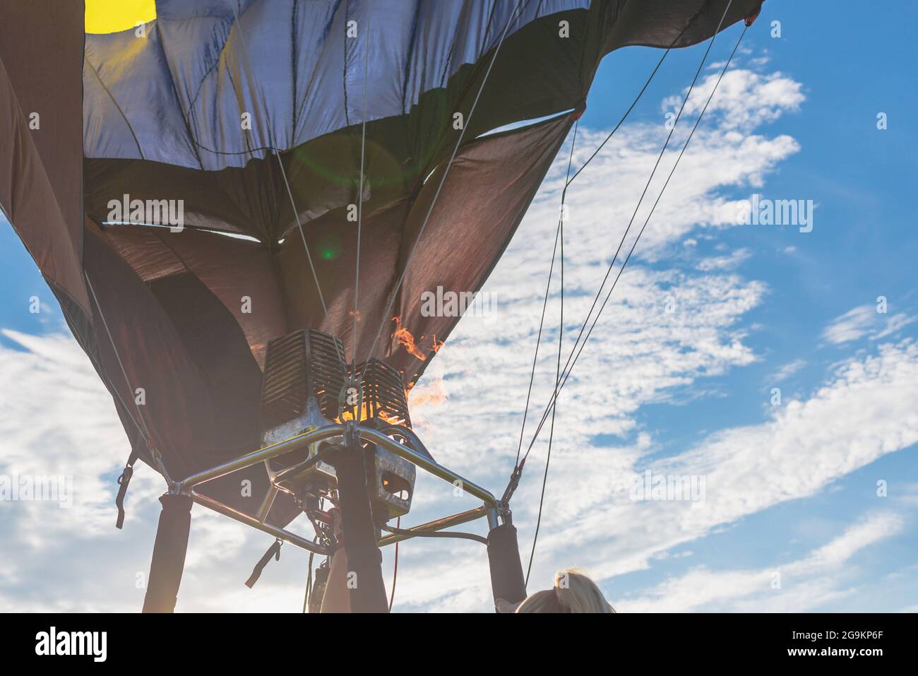 Heiße Flamme aus einem Gasbrenner leuchtet in einem Heißluftballon am Sommerabend auf. Stockfoto