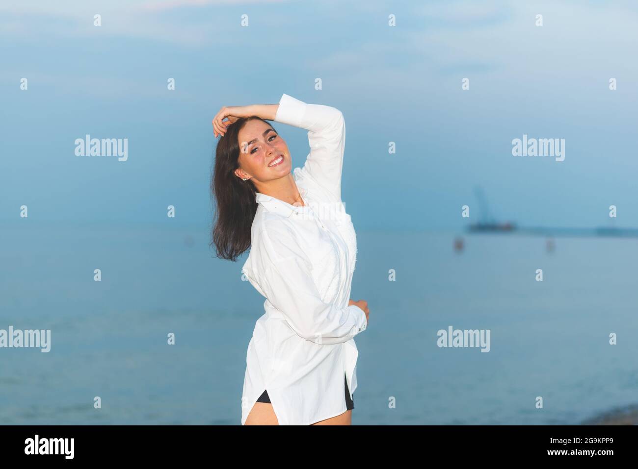 Junge hübsche Mode-Mädchen in weißem Hemd. Urlaub am Meer. Romantische junge Frau auf blauem natürlichen Hintergrund Sommer im Freien Stockfoto