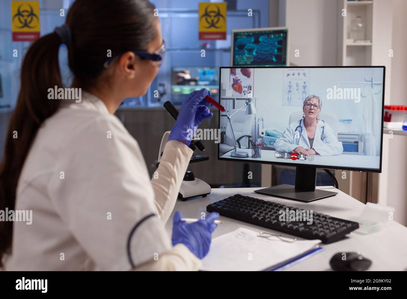 Medizinischer Forscher, der eine Videokonferenz mit einem Experten für Remote-Teamarbeit am Computer im medizinischen Labor führt. Frau trifft Spezialisten für virtuelle Diskussion über Virusbehandlung Stockfoto