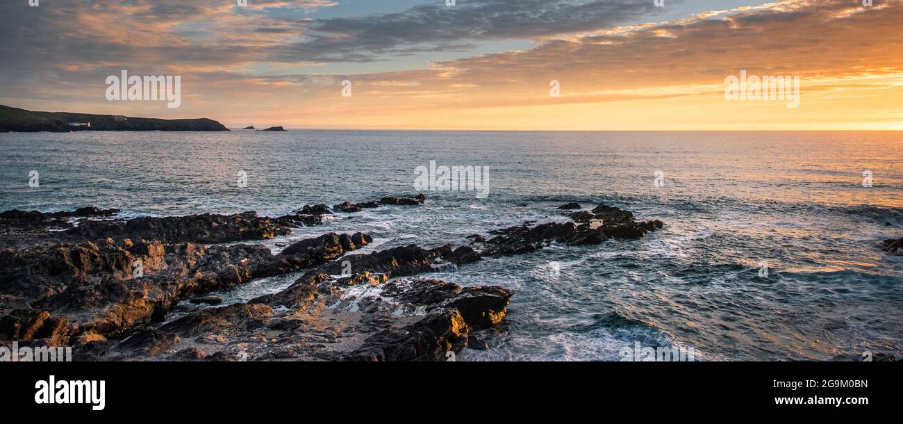 Ein Panoramabild eines spektakulären Sonnenuntergangs über der Fistral Bay an der Küste von Newquay in Cornwall. Stockfoto