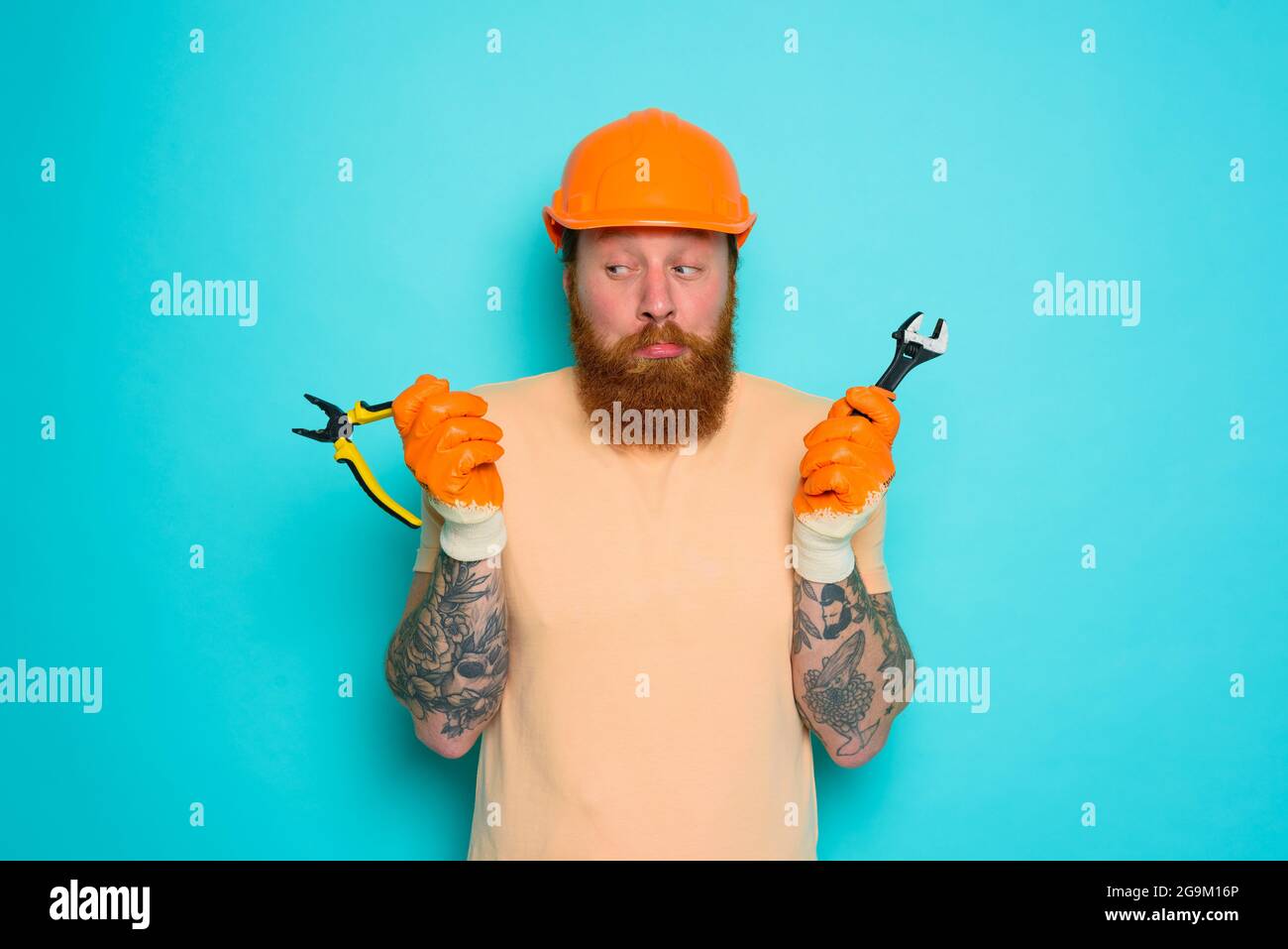 Arbeiter mit gelbem Hut ist über seine Arbeit verwirrt Stockfoto