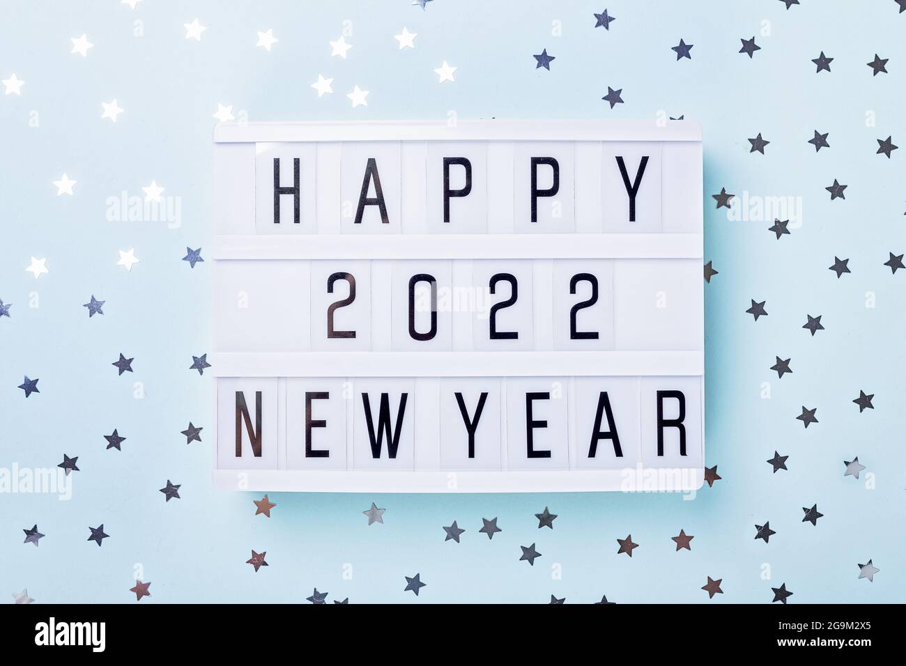 Leuchtkasten mit Text FROHES NEUES JAHR 2022 auf blauem Hintergrund. Draufsicht. Neujahr. Happy New Year 2022 Concepts - Image Stockfoto