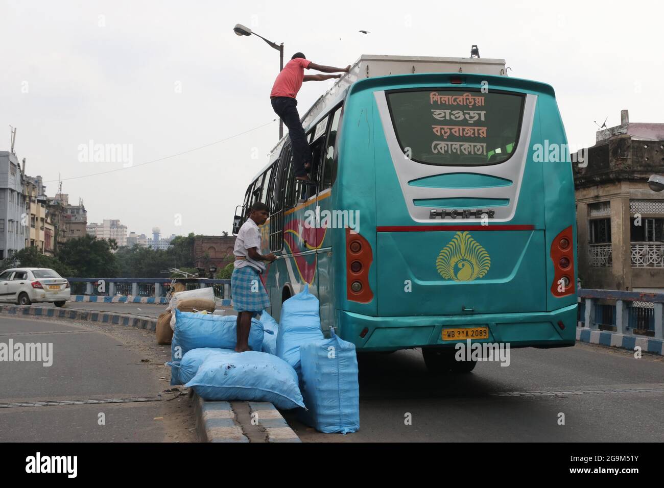 Kalkutta, Indien. Juli 2021. Während der Pandemiesituation in Kalkutta lädt ein Arbeiter Waren aus einem Personenbus auf der Straße ab. (Foto von Dipa Chakraborty/Pacific Press/Sipa USA) Quelle: SIPA USA/Alamy Live News Stockfoto