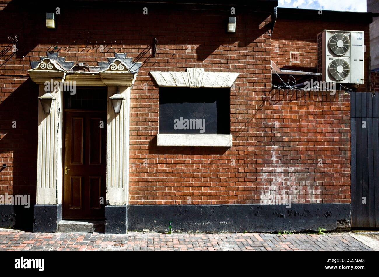 Ein altes Gebäude mit prunkvoller Tür und versperrtem Fenster. Dolch Lane, Hull Old Town Stockfoto