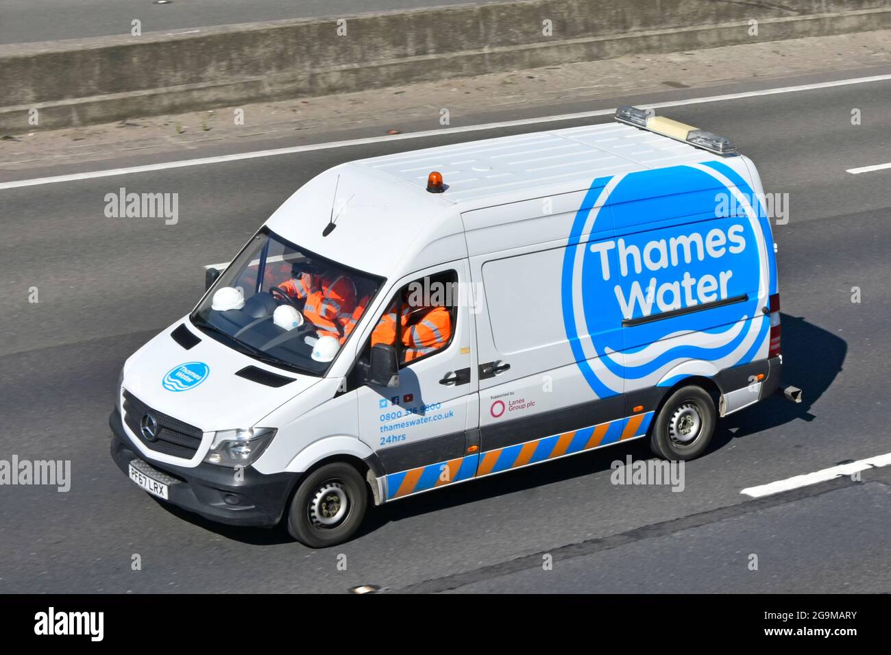 Das Logo von Thames Water und ein Team von Arbeitnehmern tragen Schutzhelme und gut sichtbare Sicherheitswesten für Arbeiter, die im Mercedes-Van auf der M25 UK zur Arbeit fahren Stockfoto