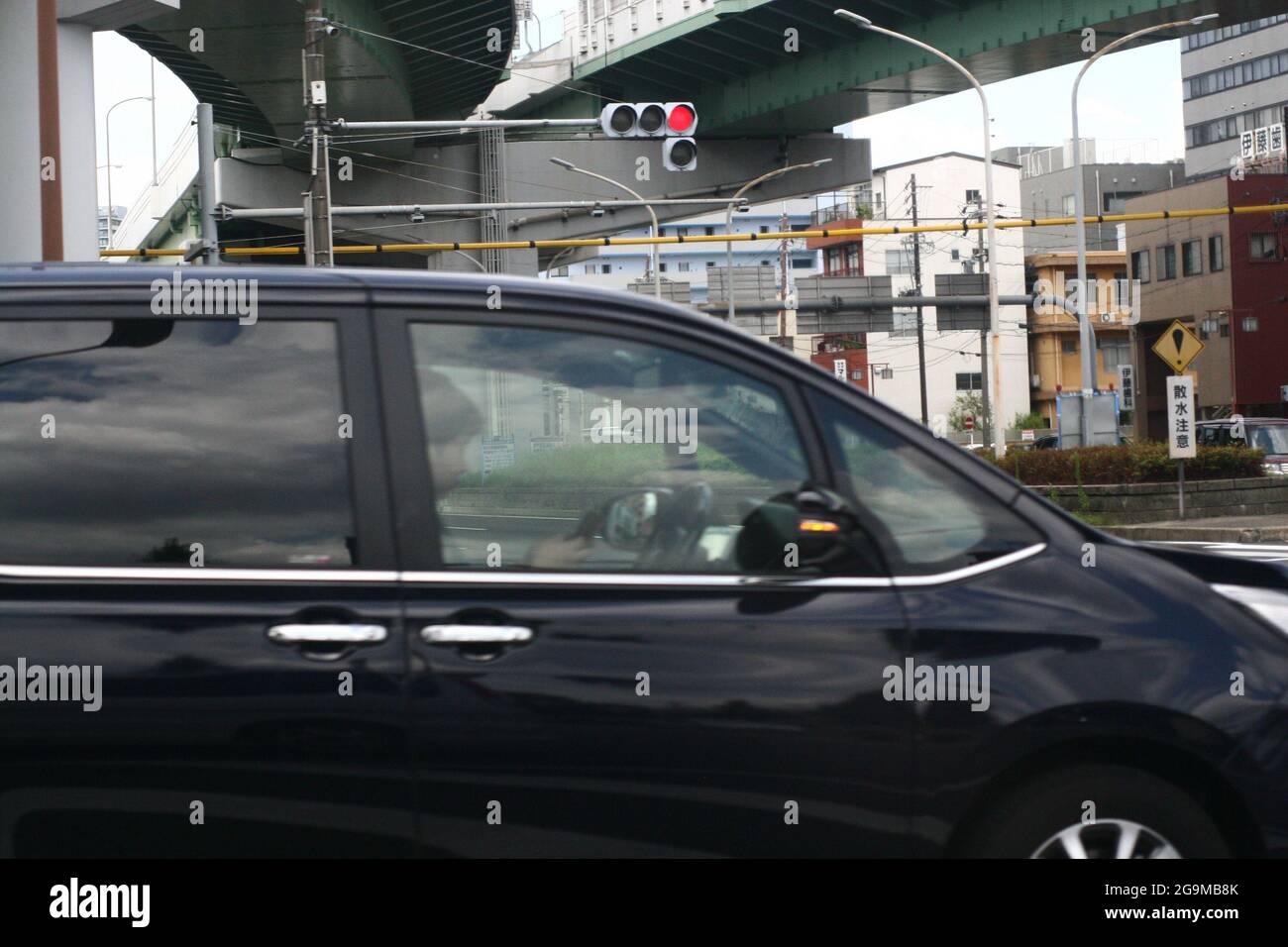 Man Texting während der Fahrt an der Kreuzung Stockfoto