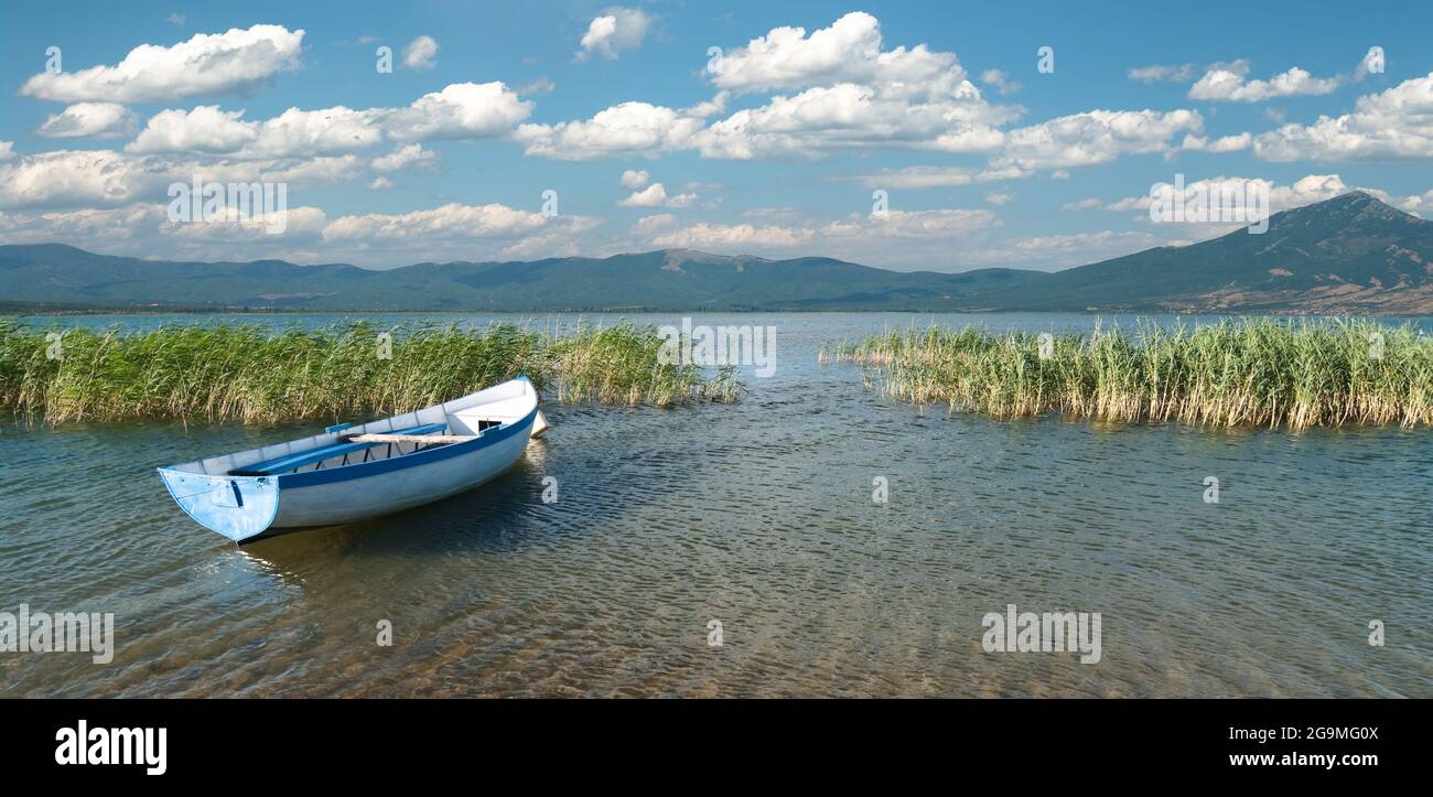 Weitblick auf ein Ruderboot und Wolkenlandschaft auf dem Prespa-See von der mazedonischen Seite Stockfoto