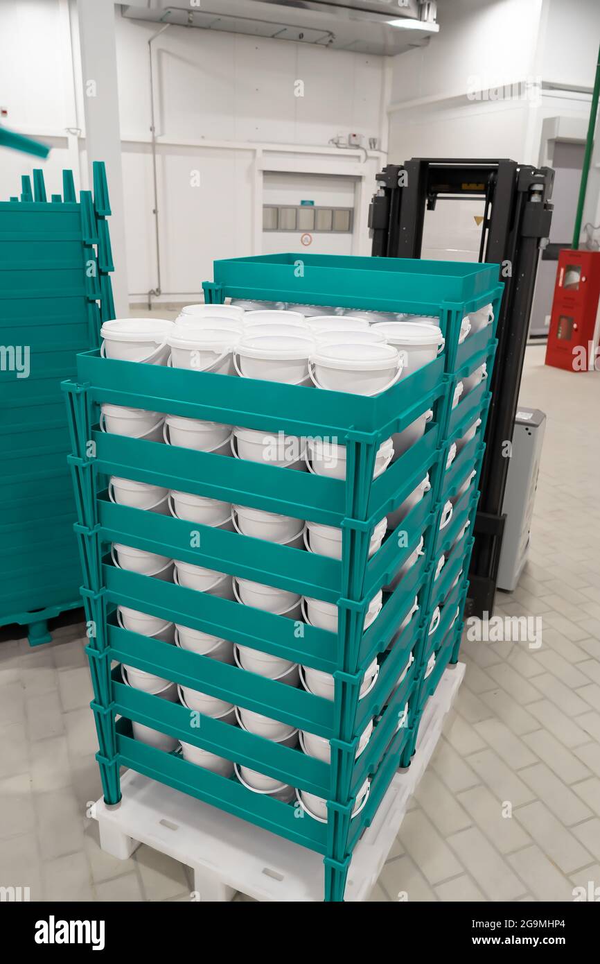 Fertigprodukte in weißen Kunststoffeimern auf Paletten. Stockfoto