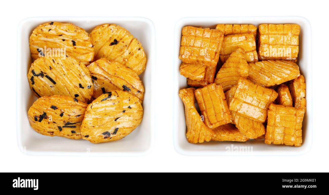 Senbei, japanische Reiscracker in weißen quadratischen Schalen. Auch halbherzige, knusprige, mundgerechte, herzhafte Snacks in verschiedenen Formen und Größen, leicht gesalzen. Stockfoto