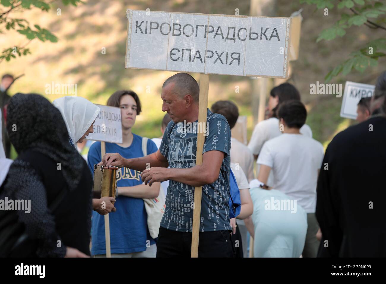 Nicht exklusiv: KIEW, UKRAINE - 27. JULI 2021 - EIN Mann spendet, während die Menschen auf den Beginn des Gottesdienstes auf dem Wolodymyrska-Hügel (St. Wolodym Stockfoto