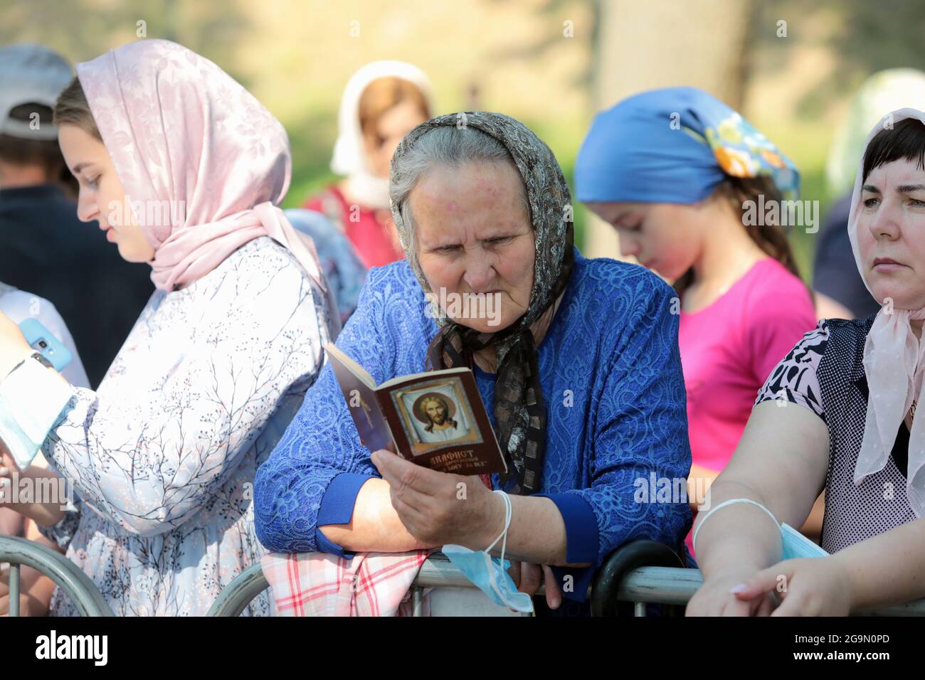 Nicht exklusiv: KIEW, UKRAINE - 27. JULI 2021 - EINE ältere Frau liest aus einem akathistischen Hymnenbuch vor Beginn des Gottesdienstes auf Volodymyrska Stockfoto
