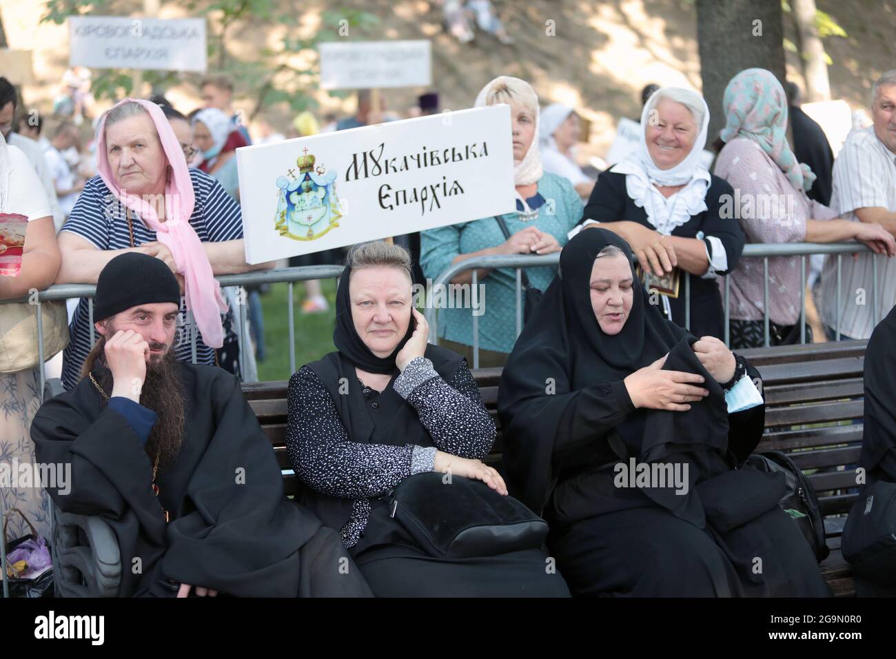Nicht exklusiv: KIEW, UKRAINE - 27. JULI 2021 - EIN Mönch und Nonnen sitzen auf der Bank vor dem Beginn des Gottesdienstes auf dem Wolodymyrska-Hügel (St. Volody Stockfoto