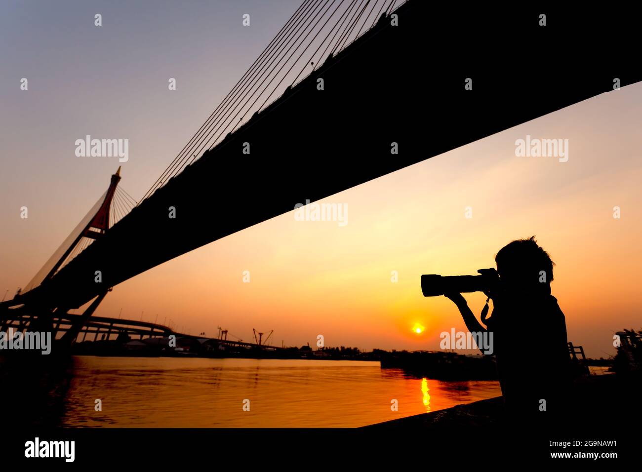 Silhouette Aufnahme eines Jungen, der bei Sonnenuntergang fotografiert Stockfoto