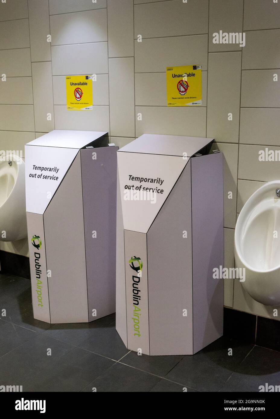 Soziale Distanzierung gelbes Schild in der Toilette von Männern oder Herren und eingewickelte Urinale, die aufgrund einer Covid-Pandemie von 19 auf dem Dublin Airport, Irland, Europa, nicht in Gebrauch waren. Stockfoto