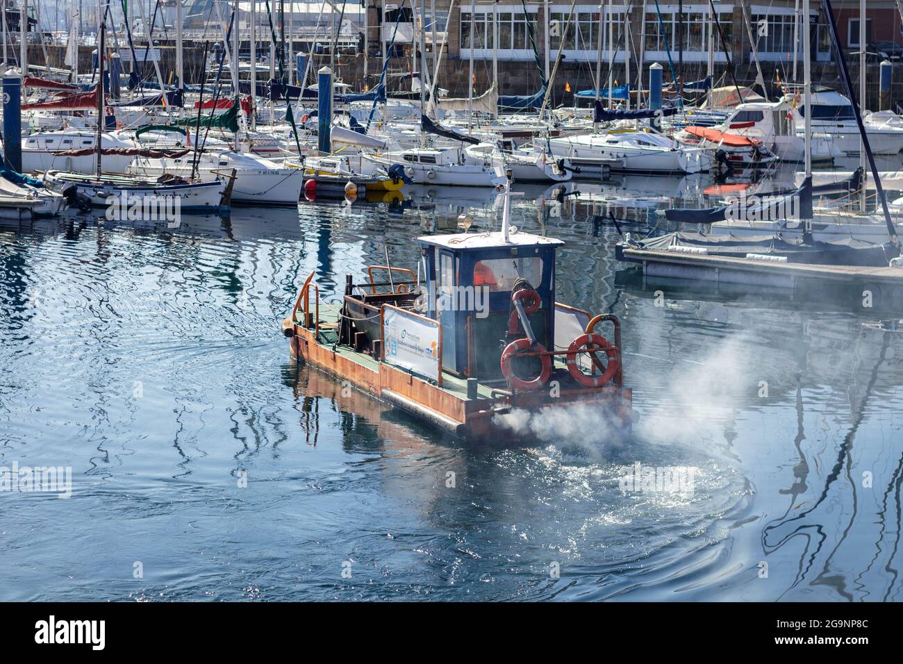 Coruna, Spanien - April 15 2021: Kommunales Abfallbeseitigung-Boot, das giftige Dieseldämpfe im Hafen von La Coruna austreten kann Stockfoto