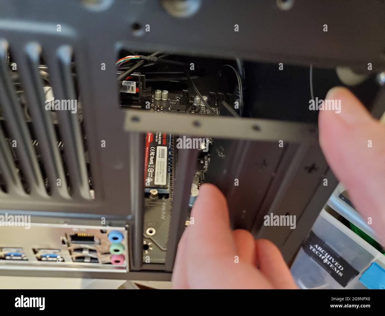 Usa. März 2021. Person, die eine Abdeckung des Erweiterungssteckplatzes mit einem SEKC SM250 128-GB-Solid-State-Laufwerk abnimmt, das in einem Desktop-PC-Gehäuse sichtbar ist, in Lafayette, Kalifornien, 18. März 2021. (Foto: Smith Collection/Gado/Sipa USA) Quelle: SIPA USA/Alamy Live News Stockfoto