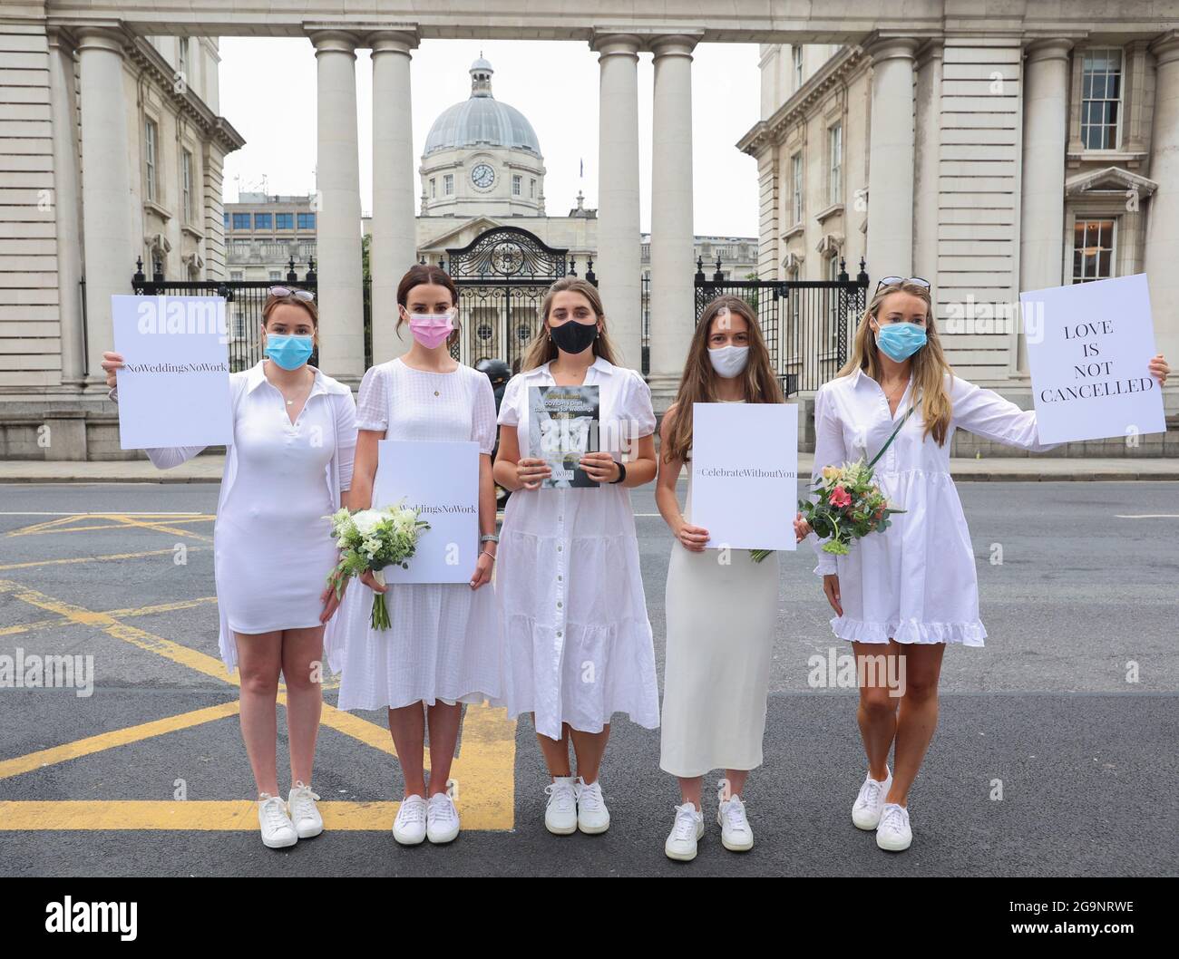 Dublin, Irland, 27/07/2021. Brides to Be protestieren vor Regierungsgebäuden in Dublin, Irland, wegen eingeschränkter Gästezahlen bei Hochzeiten aufgrund von Covid-19-Beschränkungen. Abgebildet sind (l bis r) Orla Hogan, Ali O'Mara, Brina Cullen, Anna Killeen, Orla O'Huadhaigh als eine Gruppe von Bräuten außerhalb von Regierungsgebäuden, um ihre Gesundheits- und Sicherheitsrichtlinien zu präsentieren, um ihre Hochzeiten in Schieß los. in diesem Jahr zu ermöglichen. Das Kernstück der 40 Seiten Richtlinien ist es, die Gästezahl für Hochzeitsempfänge ab August auf 100 Gäste zu erhöhen. Foto: Sam Boal/RollingNews.ie Stockfoto