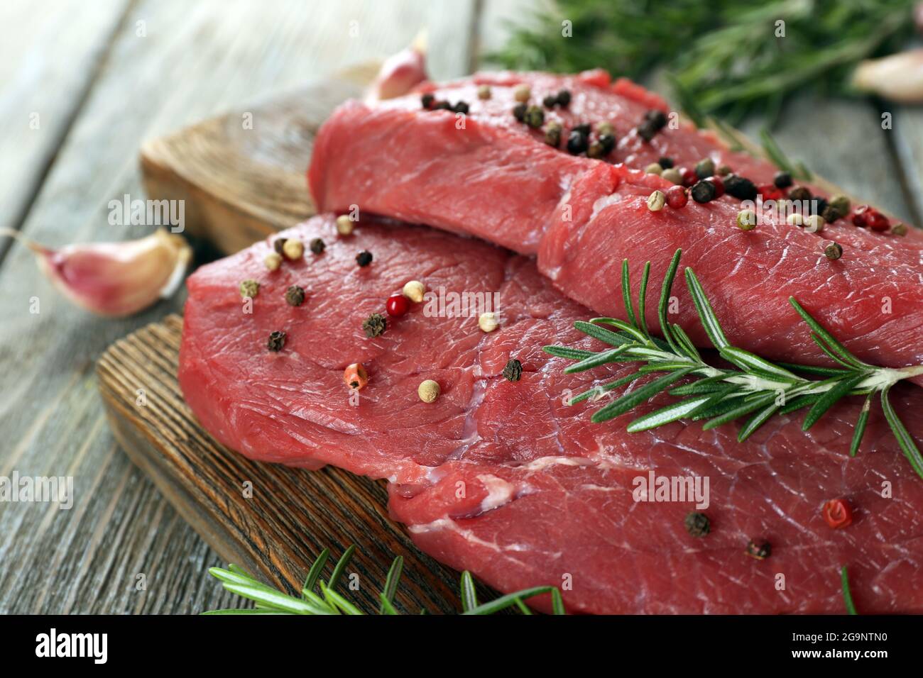 Rohes Rindfleisch Steak Mit Rosmarin Und Knoblauch Auf Schneidebrett Auf Holzernen Hintergrund Stockfotografie Alamy
