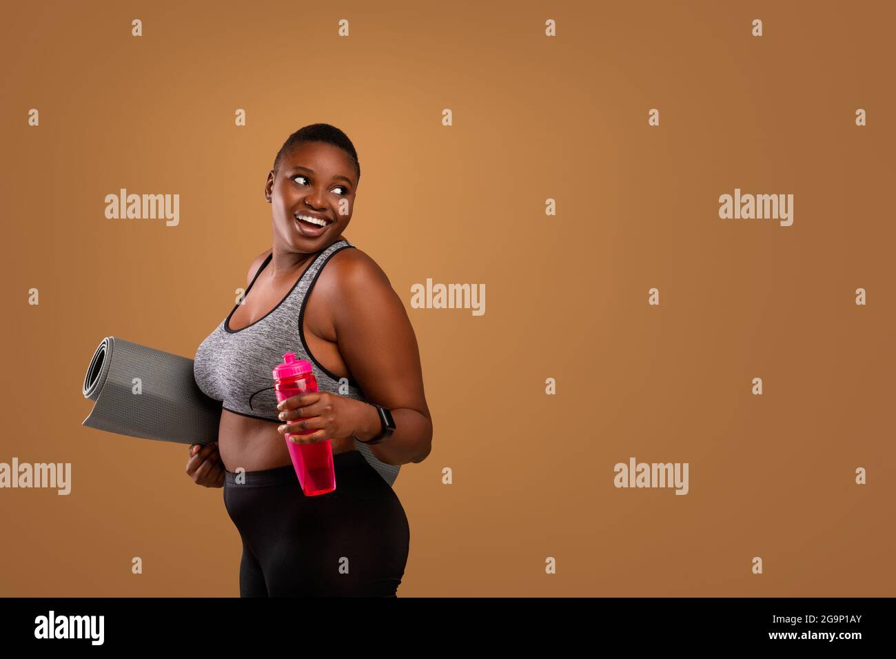 Junge Schwarze Frau Posiert Mit Matte Und Wasser Im Studio Stockfoto