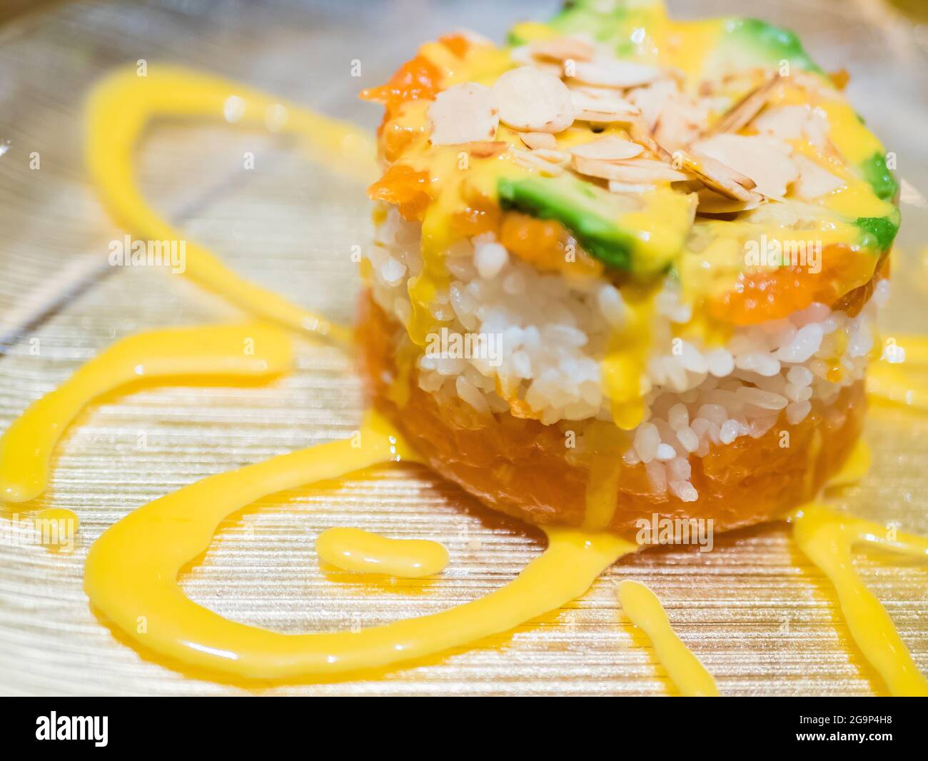 Typisch japanisches Gericht mit Sushi, Reis und Fisch, mit Sauce, Salat, Sushimi und Sesam. Japanischer Burger mit Reis, Lachs, Avocado, Mandeln und d Stockfoto