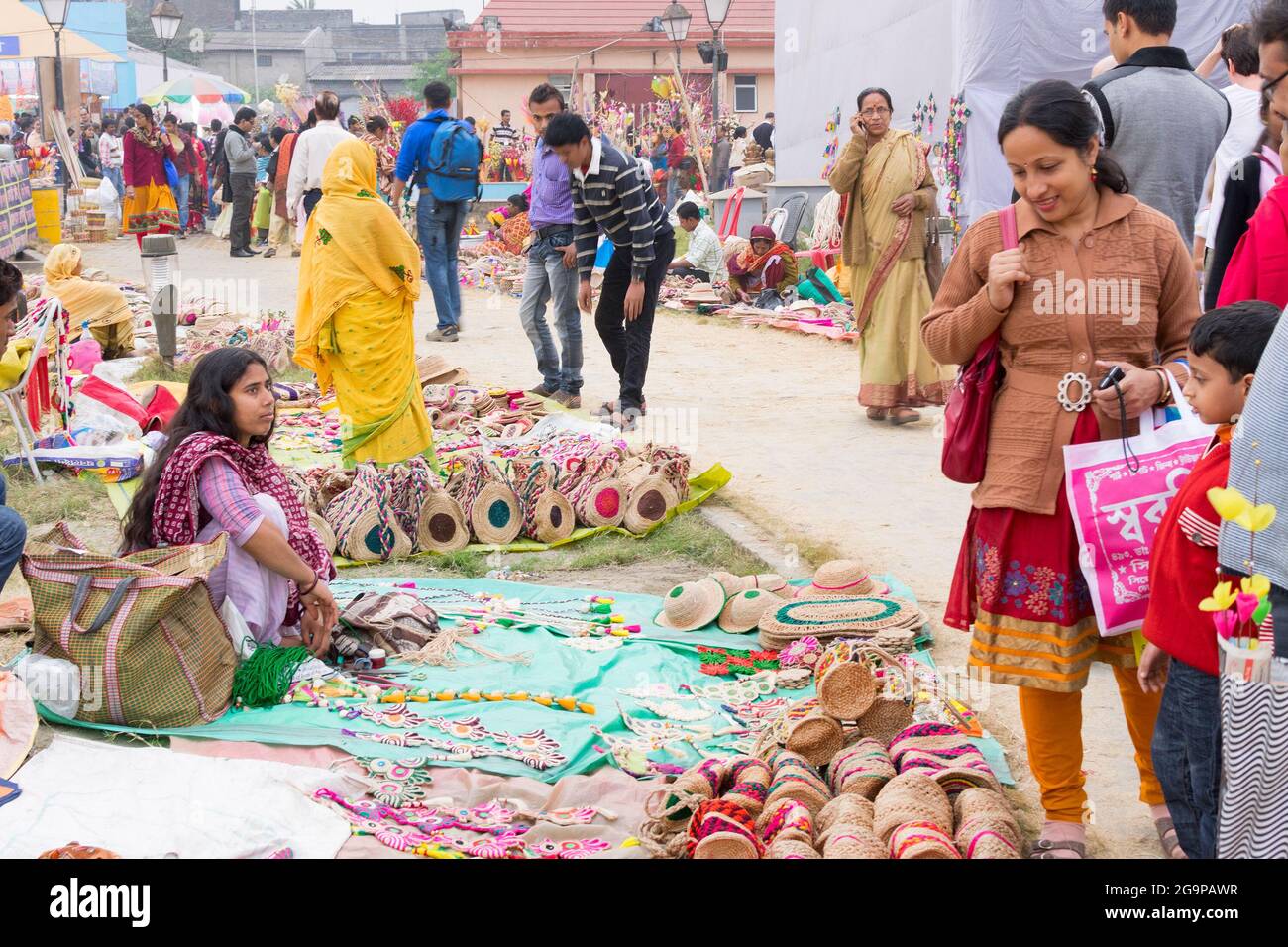 KALKUTTA, WESTBENGALEN, INDIEN - DEZEMBER 12. 2014 : nicht identifizierte indische Frauen, die handgemachte Jutepuppen und Kunsthandwerk während der Kunsthandwerkermesse handeln. Stockfoto