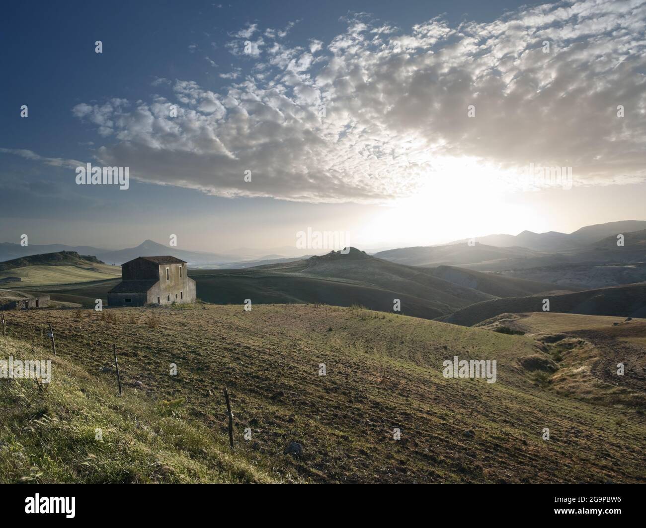 Die Sonne geht auf einem Bauernhof mit verlassenem Bauernhaus im sizilianischen Hinterland unter Stockfoto