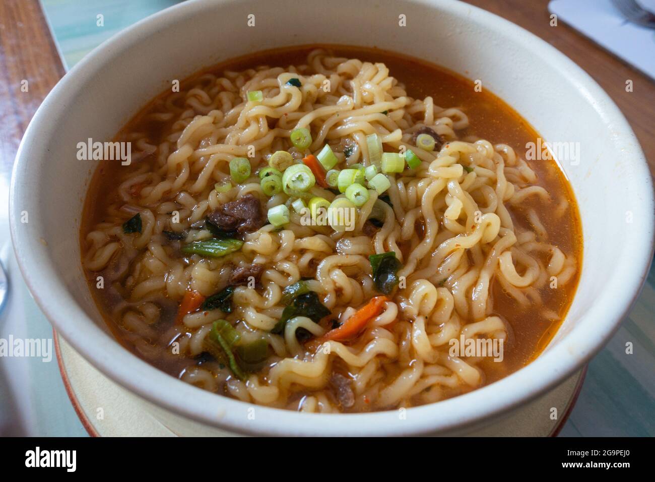 Eine Schüssel koreanische udon-Nudeln mit würziger Suppe, serviert in einer Schüssel. Stockfoto