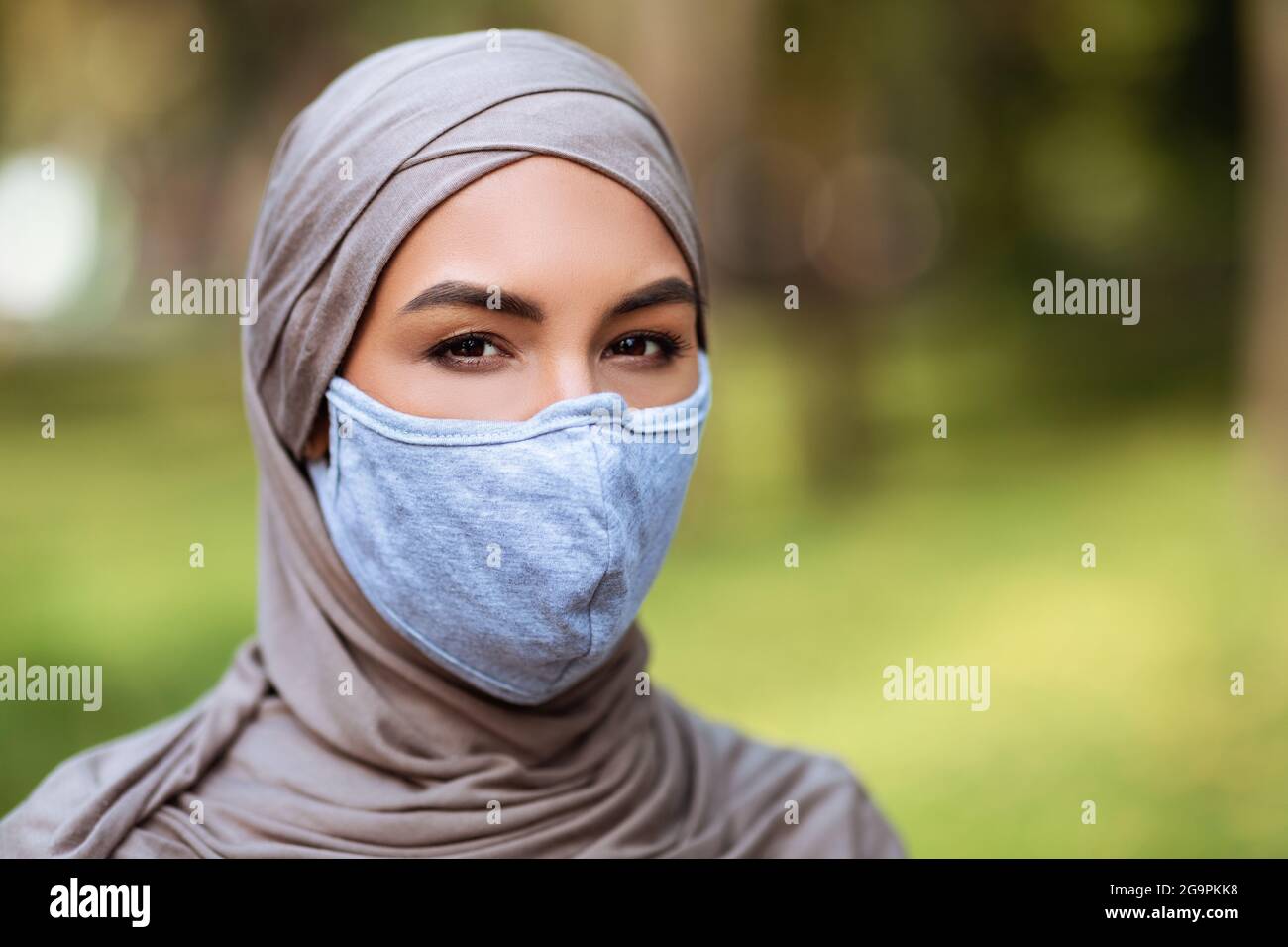 Muslimische Frau In Hijab Trägt Medizinische Gesichtsmaske Draußen Stockfoto