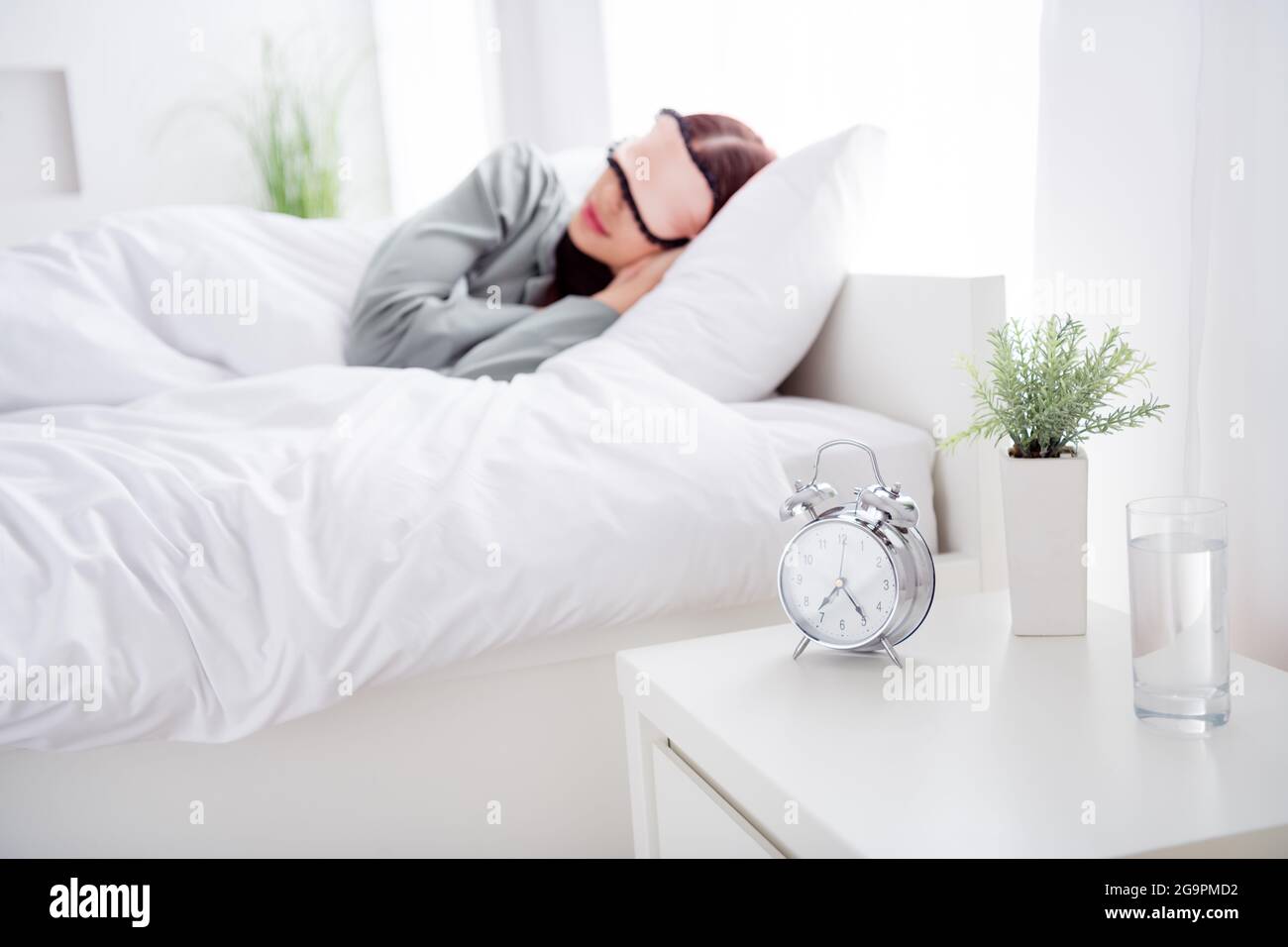 Portrait Foto Frau schlafen im Bett mit Maske in der Nähe von Wecker Wasserglas Stockfoto
