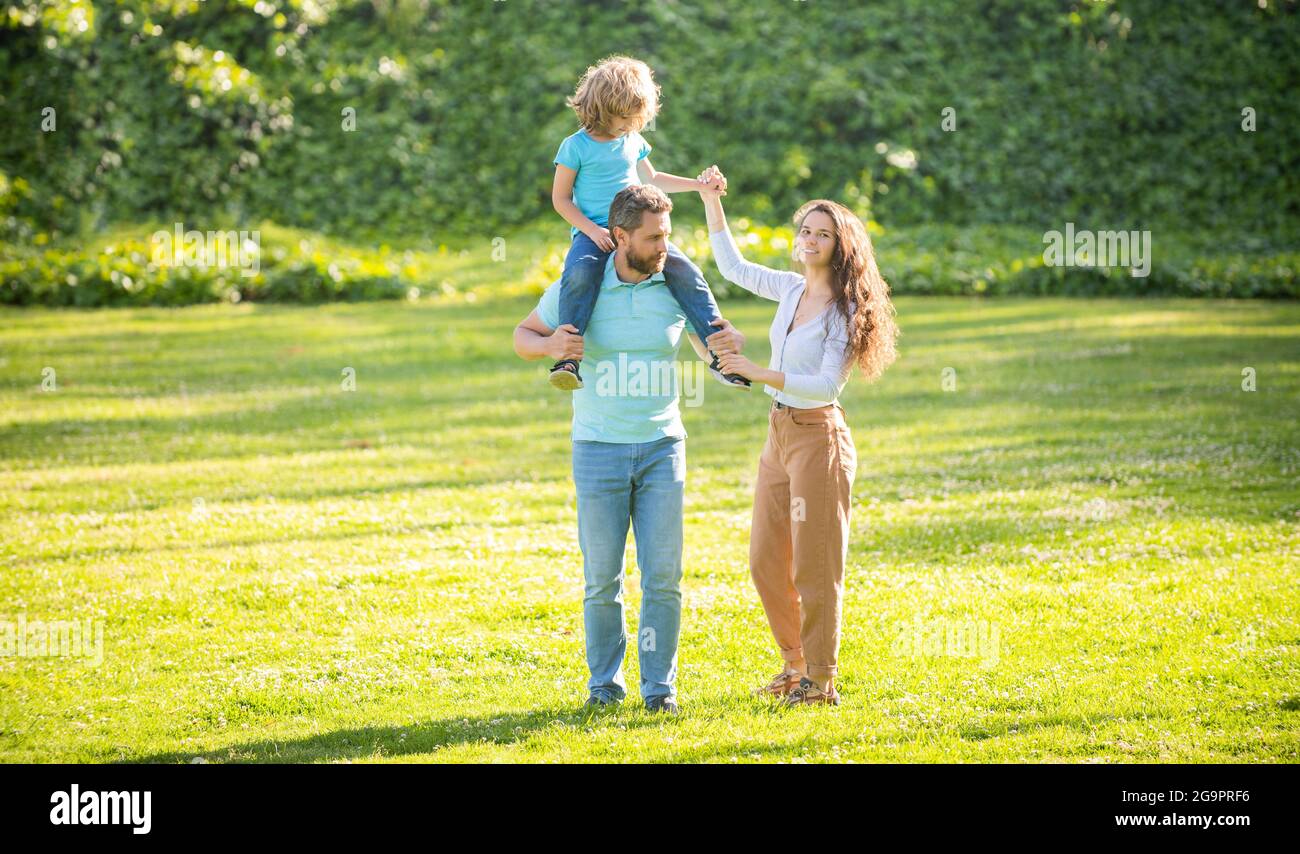 Familienurlaub. Glückliche Familie mit Kind. Mutter und Sohn reiten auf Vater. Freizeit genießen Stockfoto