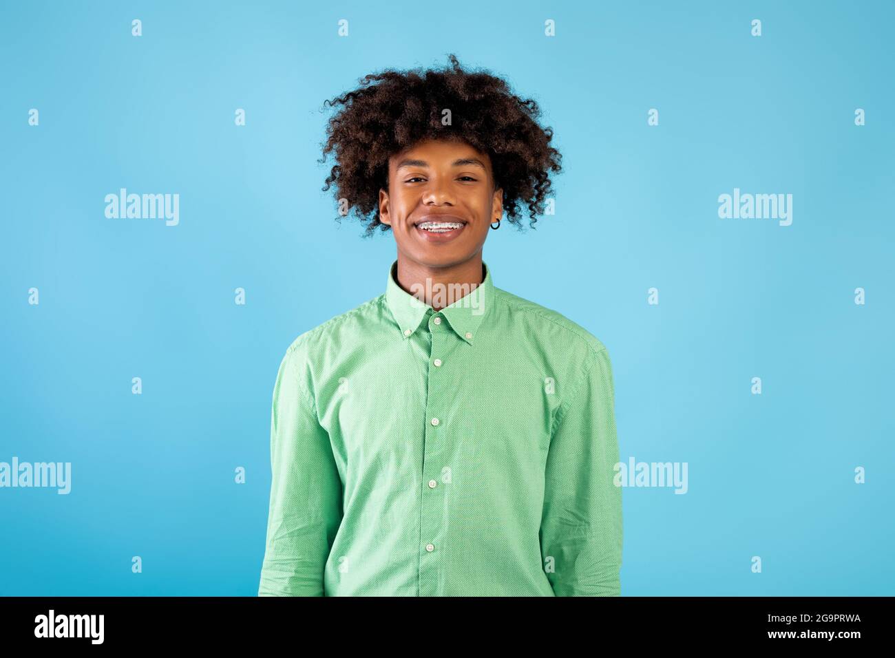 Lässiges Teenagermodell. Porträt eines lächelnden afroamerikanischen Mannes, der die Kamera auf blauem Hintergrund anschaut Stockfoto